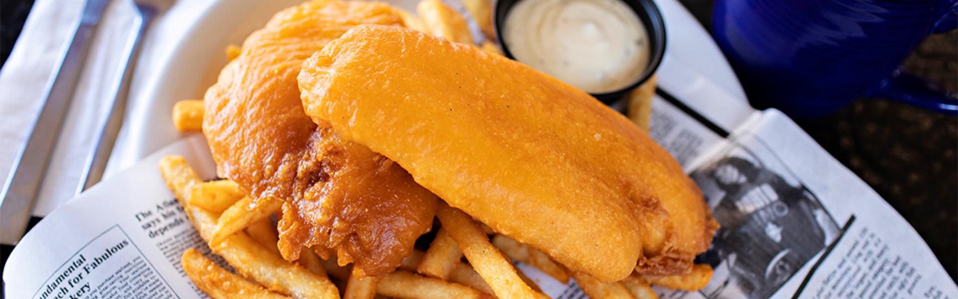 A plate of fish and chips served with tartar sauce.
