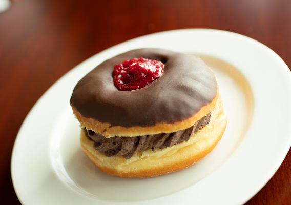 Plate of specialty cream donut with strawberry topping 